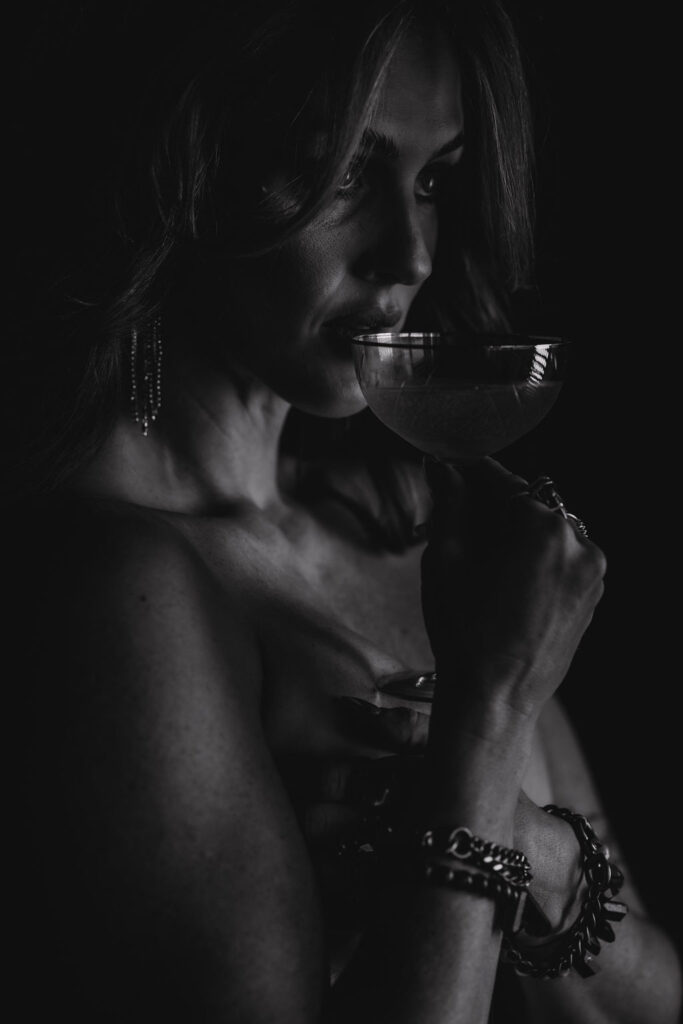 Elegant black and white branding photography of a woman sipping from a glass, showcasing bartending services