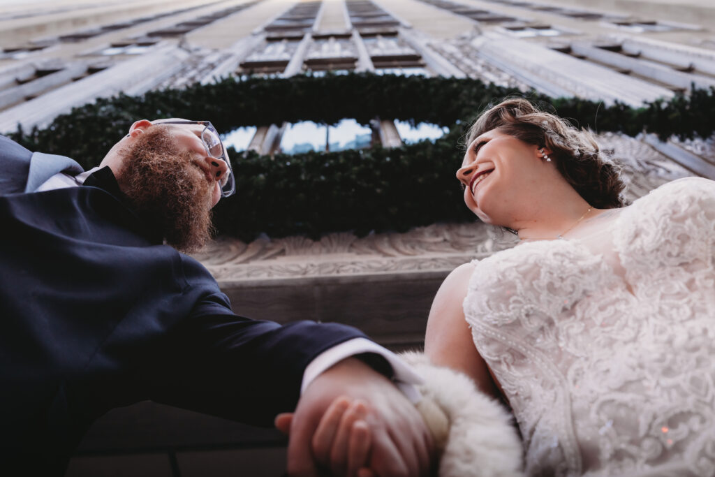Oklahoma photography of a newlywed couple holding hands and smiling at each other on their wedding day.