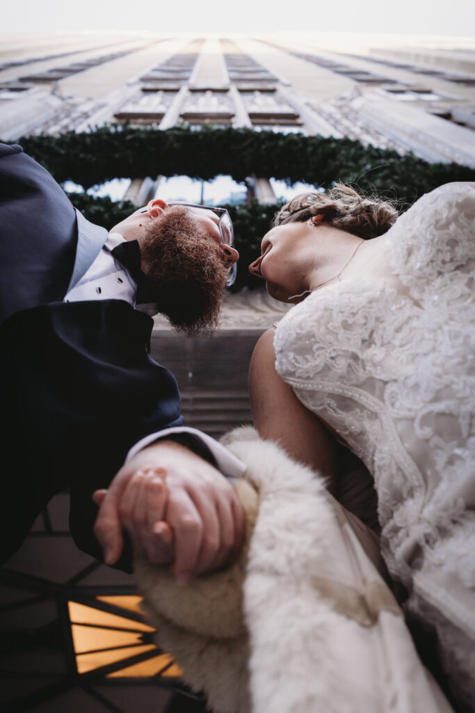 Wedding photography and videography of a newlywed couple holding hands and looking at each other during their Oklahoma wedding.